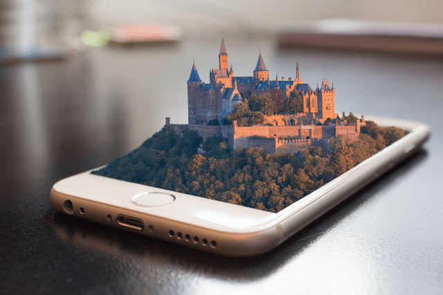 An IPhone with a fantasy 3D castle on top of the screen
